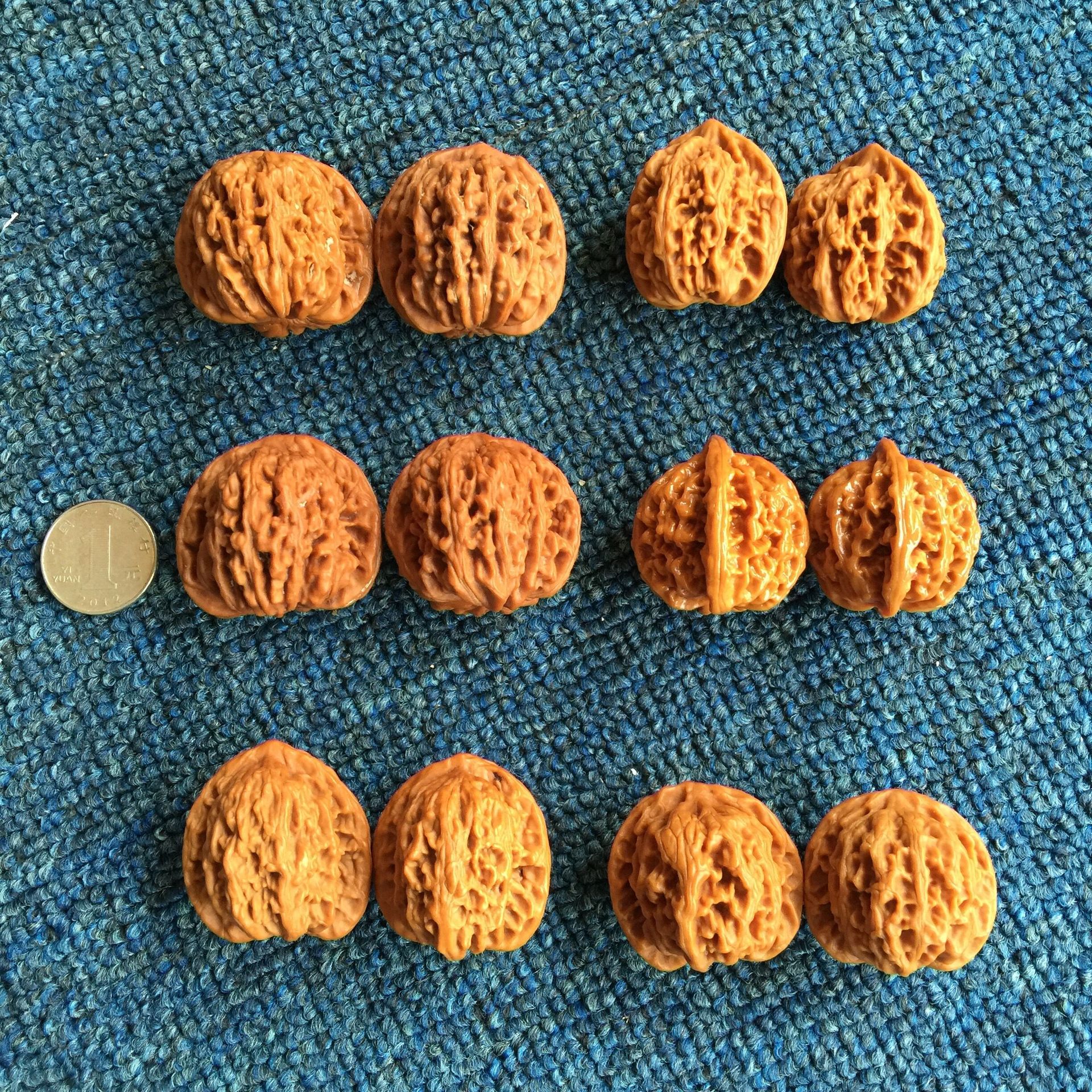 一对深褐色麻核桃用红色丝线串联,静置于黑色檀木盒内,背景为中国风布艺纹理,核桃表面雕刻般纹理清晰可见,象征传统文化与养生理念的结合 一对纹理对称的麻核桃悬挂在红绳上,置于古朴木盒中