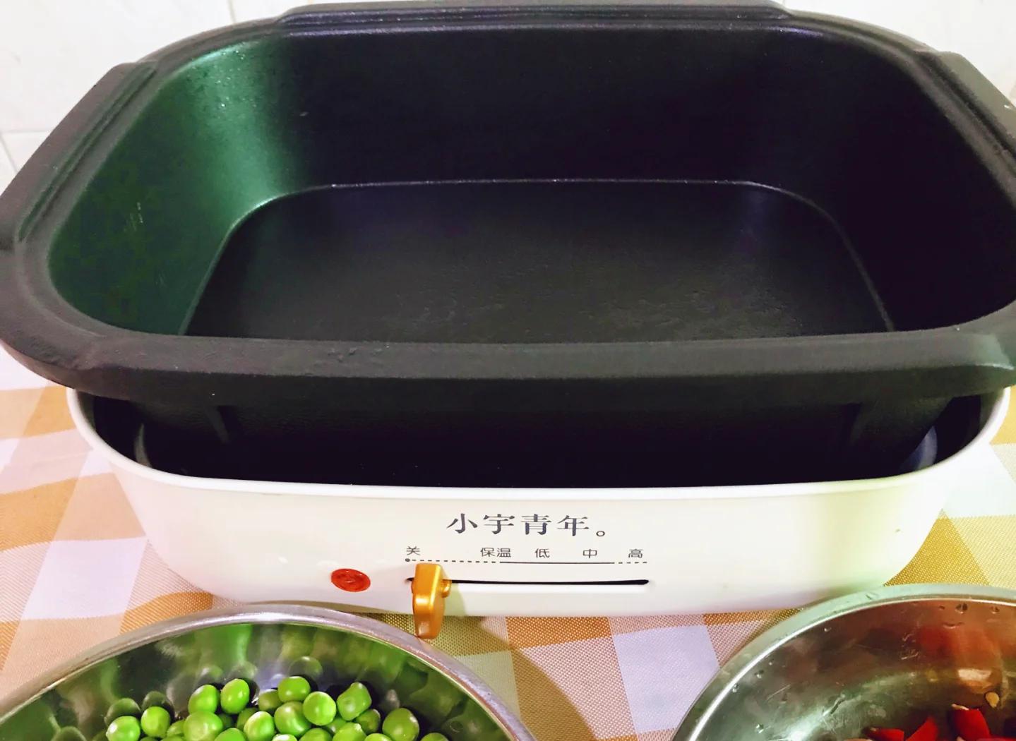 家庭厨房中正在翻炒青豌豆的场景