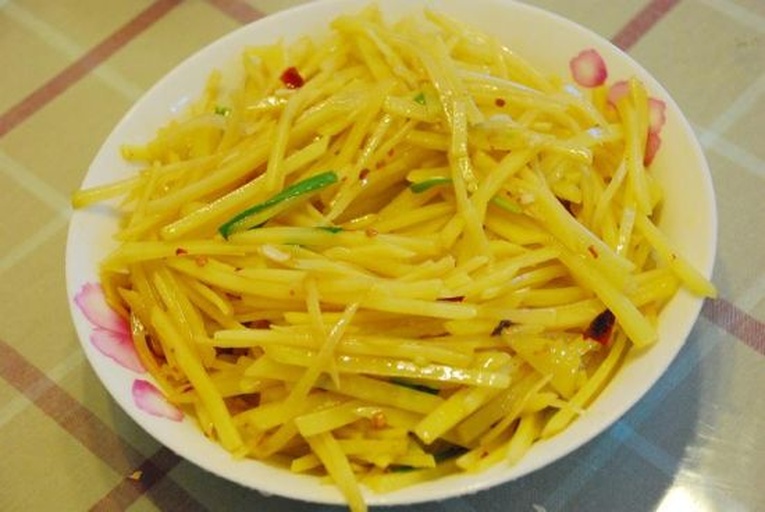 厨师手持长筷在铁锅中快速翻炒土豆丝，锅内白雾升腾（醋蒸汽），土豆丝根根分明呈半透明玉白色，锅边可见淋入的醋液反光，灶火呈明亮蓝色火焰