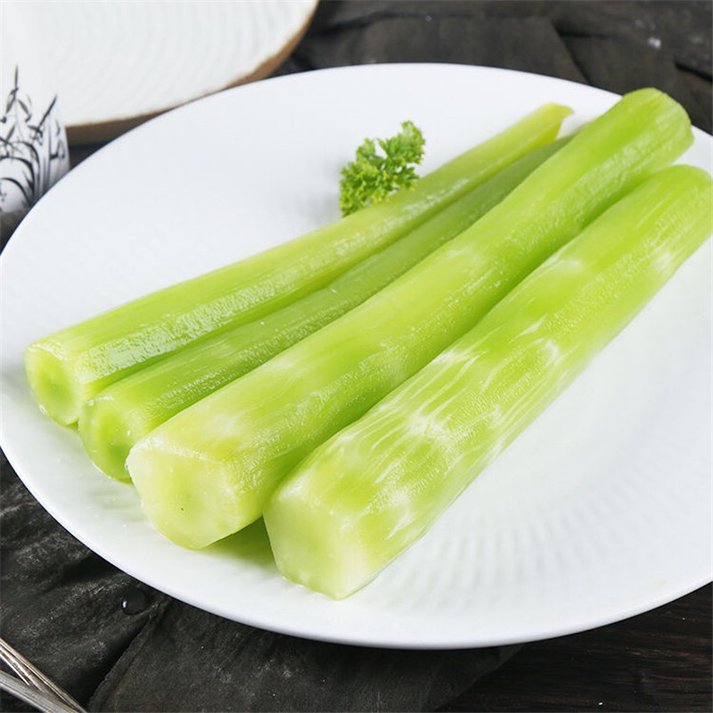 芦笋与油菜并列摆放于木质砧板上，背景为厨房自然光环境，芦笋呈翠绿色笔直状，油菜叶片鲜嫩完整，根部带少量泥土，体现新鲜采摘状态