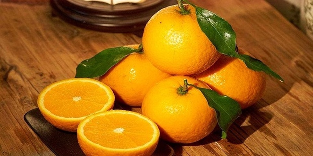 一张白色背景桌上摆放着一个切开的山竹、两个完整山竹、一串荔枝、一根香蕉、一个橙子和一个苹果,所有水果均为新鲜状态,光线柔和,用于展示不同水果之间的体积与颜色差异,便于热量对比说明 山竹与多种水果并列摆放