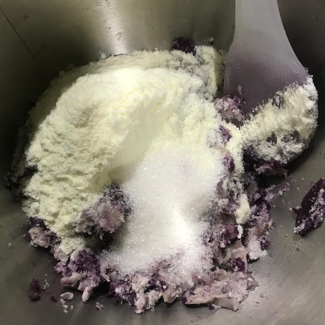 一只手正在将金黄色的芒果泥缓缓倒入锅中的紫色芋头奶浆中,两者正在融合形成柔美渐变色,锅具为不锈钢奶锅,背景虚化显示厨房操作台 制作过程特写图