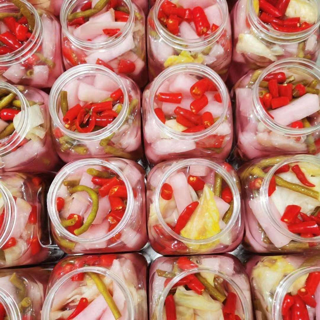 泡椒与透明玻璃罐中的红色泡椒水特写