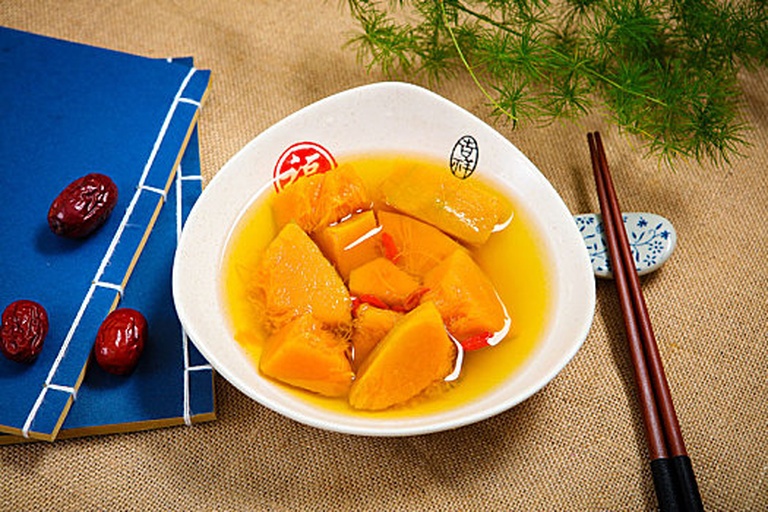 一位成年人正在用勺子喂食婴儿南瓜泥