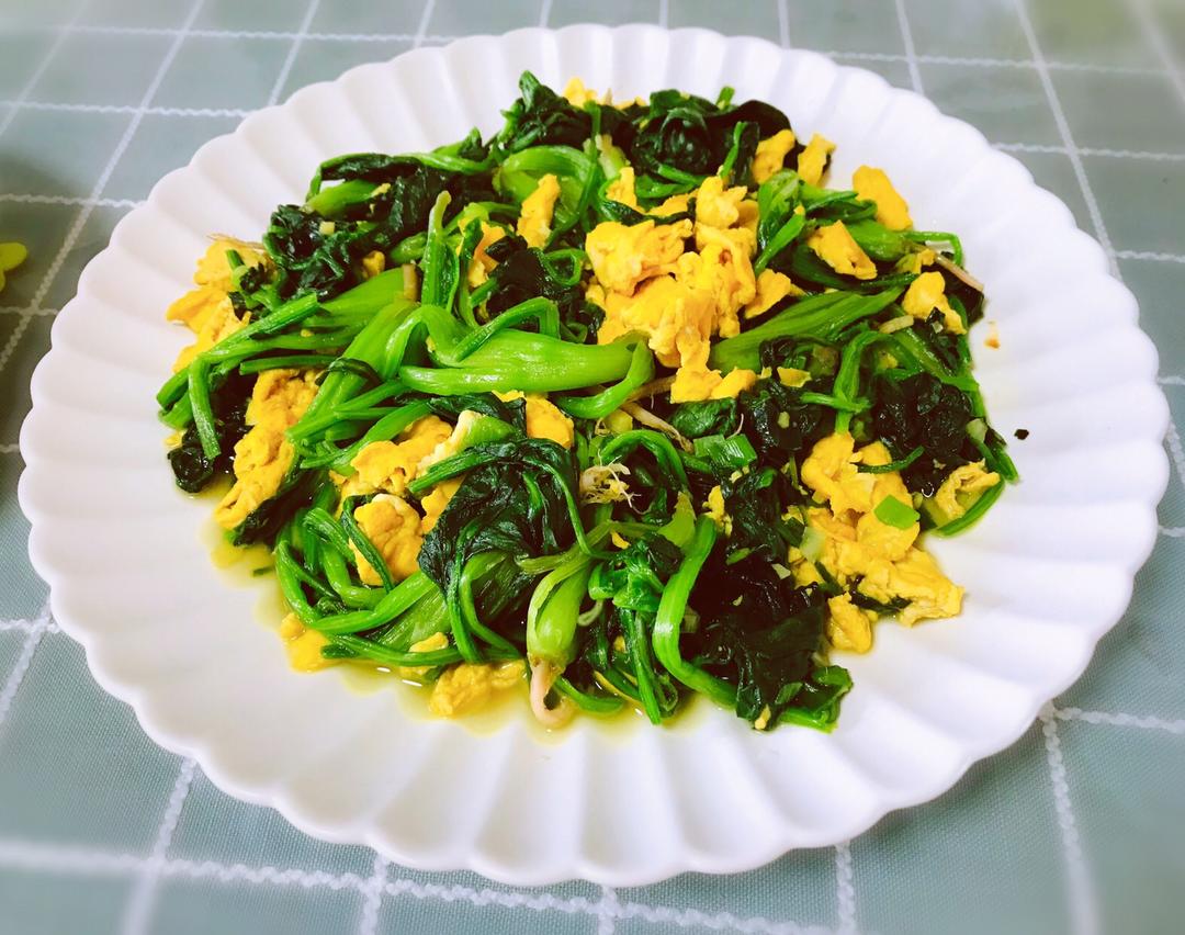 厨房操作台场景：不锈钢研磨器中盛放刚磨好的淡黄色鲜姜泥，旁边摆放带刻度的玻璃量杯（显示15mL姜泥）、土鸡蛋2枚、玻璃碗中已打散的蛋液，背景可见小火灶具