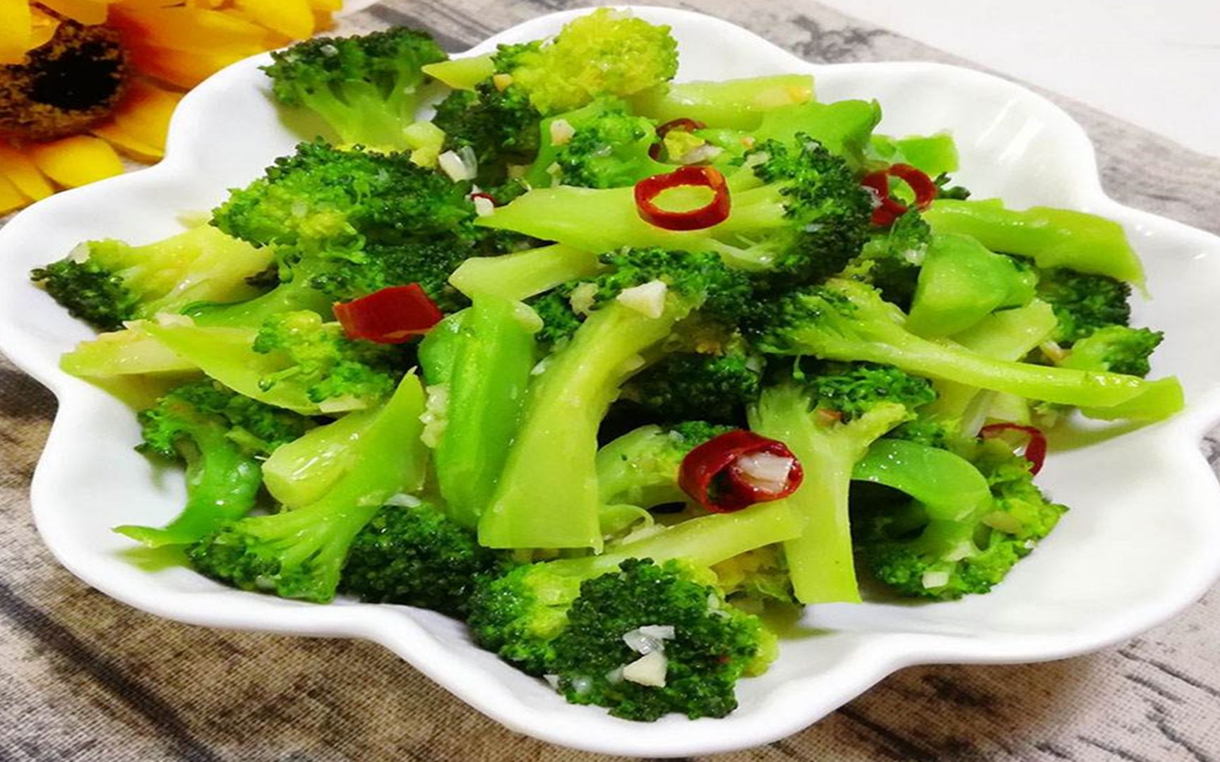 西兰花与油菜家常快炒过程实拍:展示科学火候控制与食材状态变化,体现‘断生不软烂’的营养保留关键点 家庭厨房场景:不锈钢炒锅中正在翻炒西兰花与油菜,食材色泽鲜亮,西兰花呈翠绿色带微焦边,油菜叶片舒展油润,锅中可见少量蒜末与透明汁液,灶火为中大火状态