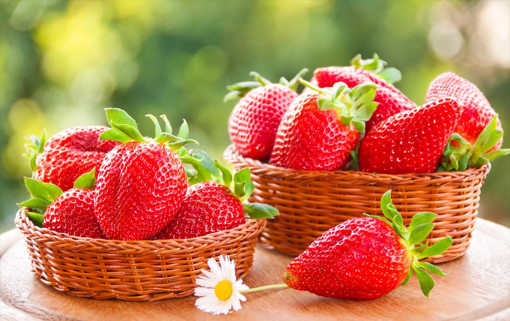 一张对比图显示一颗金桔与草莓、蓝莓、樱桃并列摆放,突出其体积大小关系,背景为木质餐桌,光线柔和,体现生活化场景 金桔与常见水果对比图