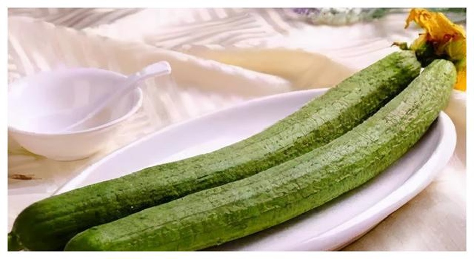 市售瓶装丝瓜水护肤品与新鲜丝瓜并列摆放对比图