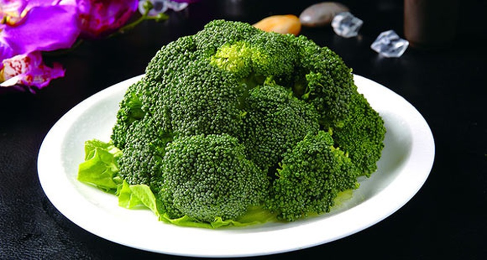 一株新鲜翠绿的西兰花与另一株已经边缘发黄、花蕾松散的西兰花并列摆放,清晰展示颜色变化过程,背景为厨房台面,光线自然 西兰花从绿色变为黄色的过程特写