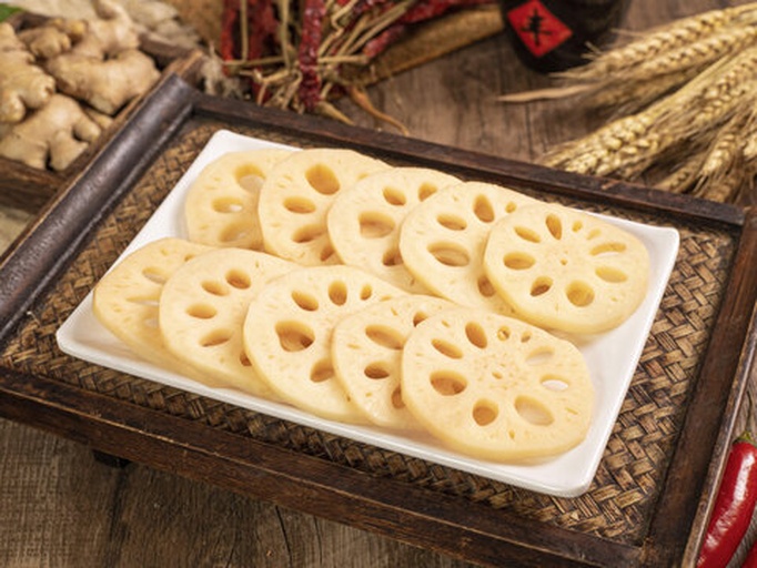 家庭烹饪场景：锅中炖煮莲藕排骨汤，旁边摆放切好的白莲藕片准备凉拌