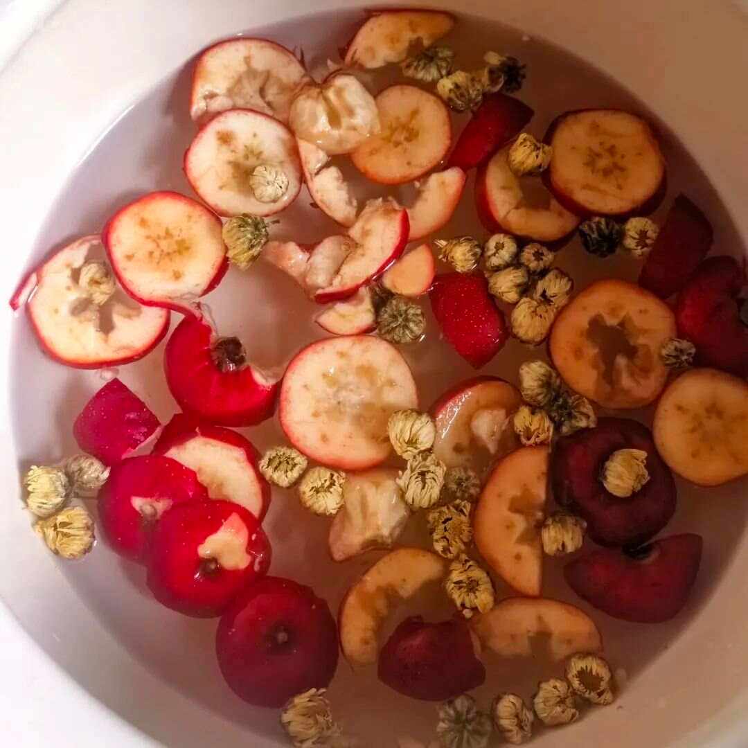 展示一杯清澈的苹果山楂水,旁边摆放苹果片和山楂干 苹果山楂水成品展示图