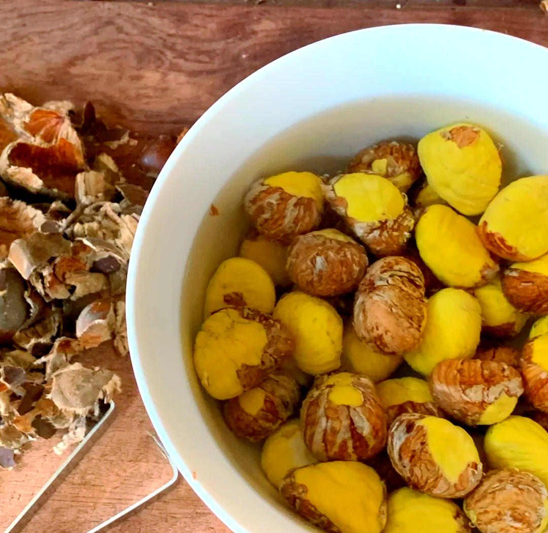 家庭厨房中正在剥板栗的操作场景