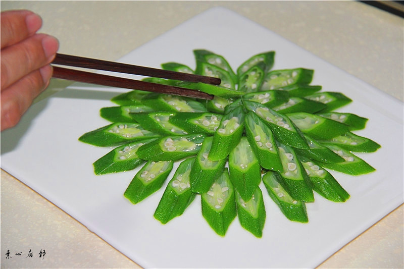 新鲜秋葵与生菜组合摆拍图,展示食材原始状态 秋葵和新鲜生菜并列摆放于木质砧板上,背景为厨房自然光环境,左侧是带绒毛的绿色秋葵荚果,右侧是翠绿卷曲的生菜叶片,旁边有小刀和橄榄油瓶