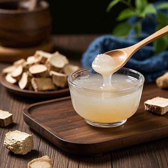 一个白色陶瓷碗中正在冲泡葛粉,一只手正将热水缓缓倒入碗中,液体逐渐变为半透明胶状,热气袅袅上升,旁边摆放着一勺白色的葛粉和玻璃水壶,背景为木质餐桌,整体画面温馨自然,突出家庭养生场景 葛粉冲泡过程特写