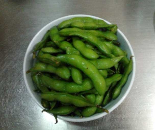 手部特写正在快速剥开绿色毛豆荚