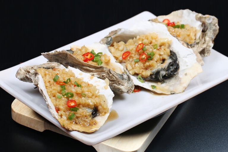 高清蒸制过程图:不锈钢双层蒸盘盛放生蚝,可见每只蚝肉饱满、裙边舒展,调味汁均匀覆盖,蒸锅处于全封闭状态,水汽从排气阀稳定喷出 蒸生蚝过程特写:不锈钢蒸盘中整齐摆放10只生蚝,裙边朝上,表面淋浅褐色豉油汁,撒金黄姜末与翠绿葱丝,蒸锅内水汽升腾,锅盖边缘无漏气