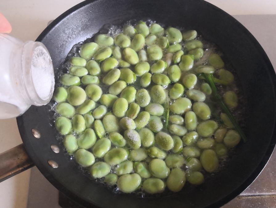 家庭厨房中进行蚕豆焯水与冰水冷却过程