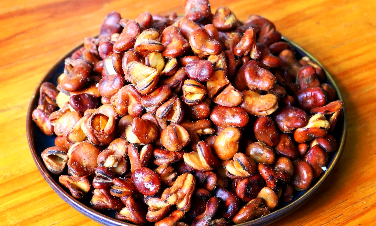 工业级高清摄影:洁净车间内,不锈钢全自动流水线正在分选、蒸煮、真空低温烘烤带壳蚕豆;机械臂精准抓取金黄色成品投入金属托盘;背景可见温控仪表屏与‘高蛋白植物零食’LOGO标识,体现蚕豆从初级农产品向健康食品升级的现代化进程 现代食品工厂中自动化生产线加工蚕豆制品