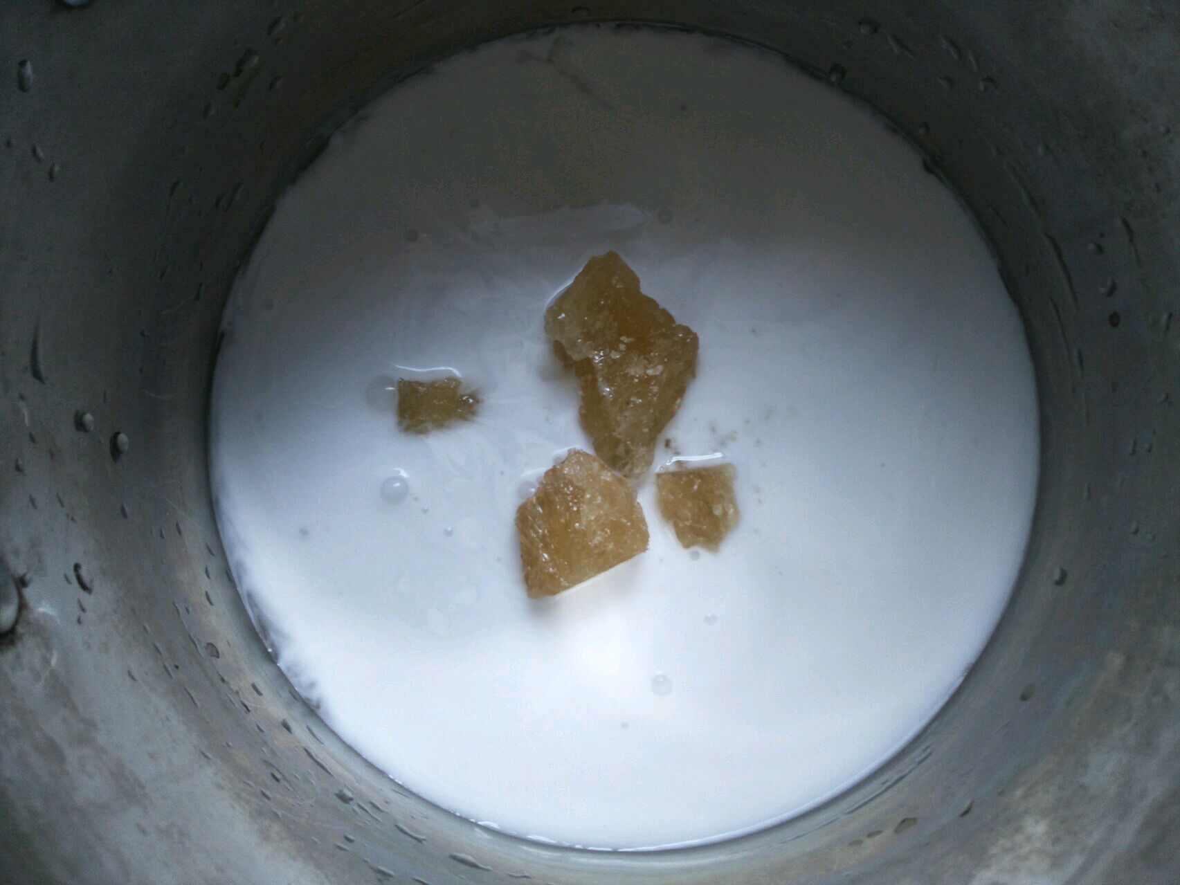 一个不锈钢奶锅正在炉灶上小火慢煮,锅内可见漂浮的雪梨块、陈皮丝和罗汉果碎片,蒸汽袅袅升起,背景虚化的计时器显示‘00:15’ 熬煮过程特写