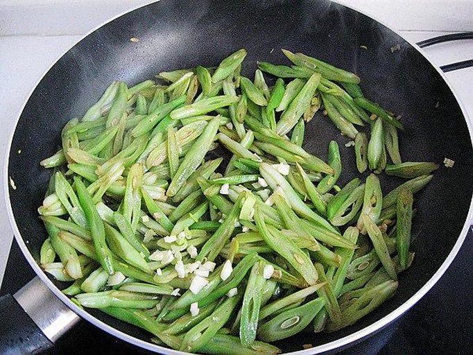 家庭厨房中炒制四季豆的场景