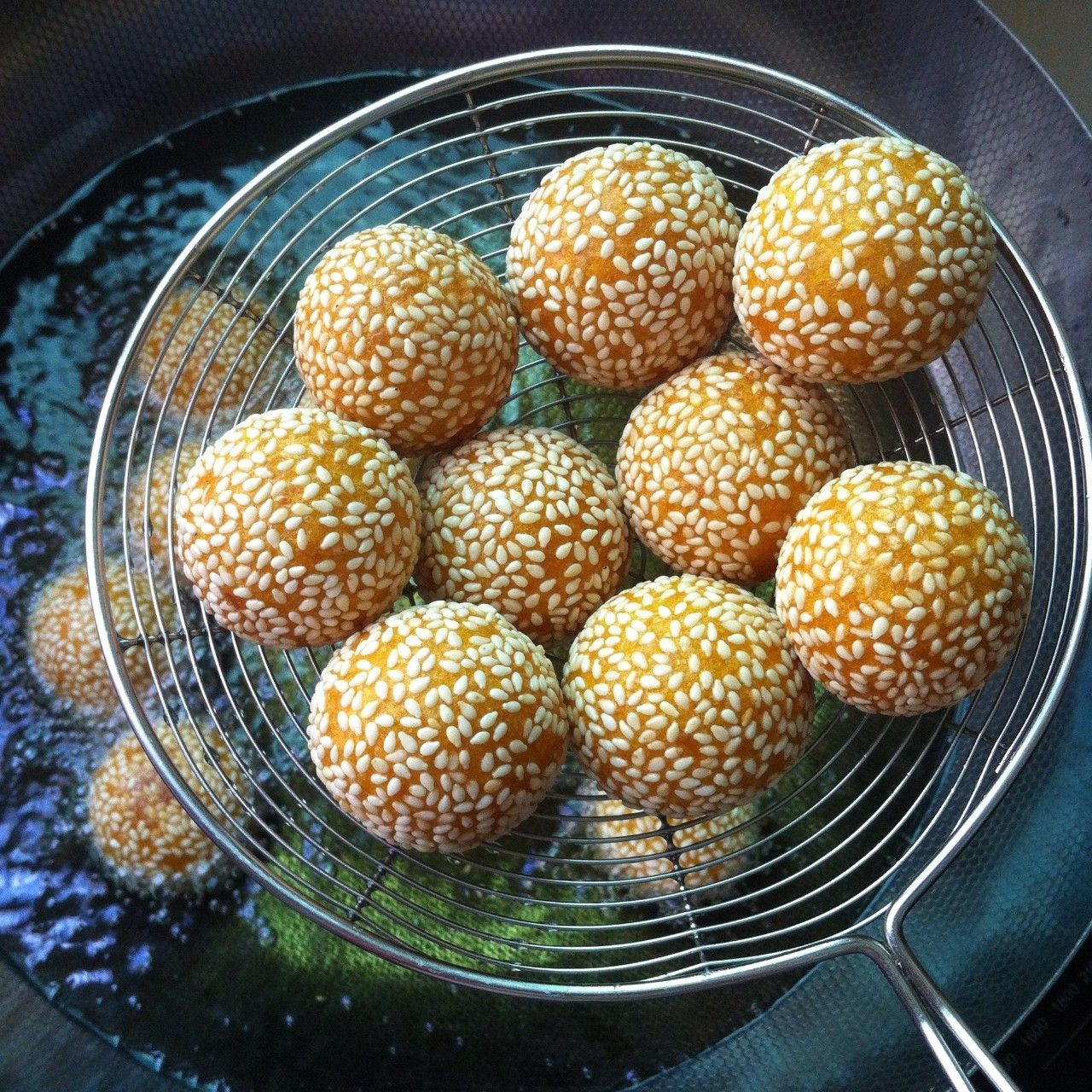 豆沙芝麻球炸制完成,外皮金黄酥脆,芝麻均匀覆盖 炸制豆沙芝麻球的成品图
