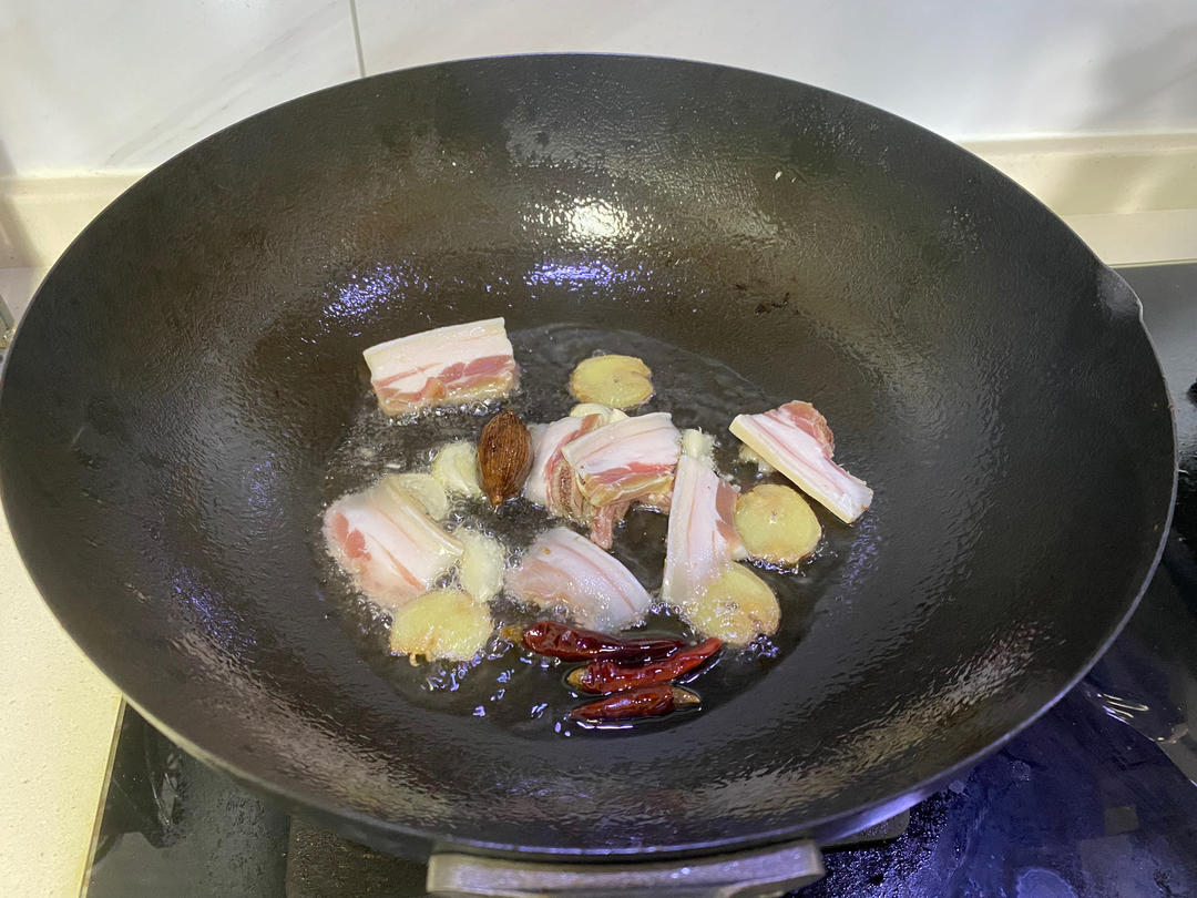 煸炒五花肉与香料的锅中场景