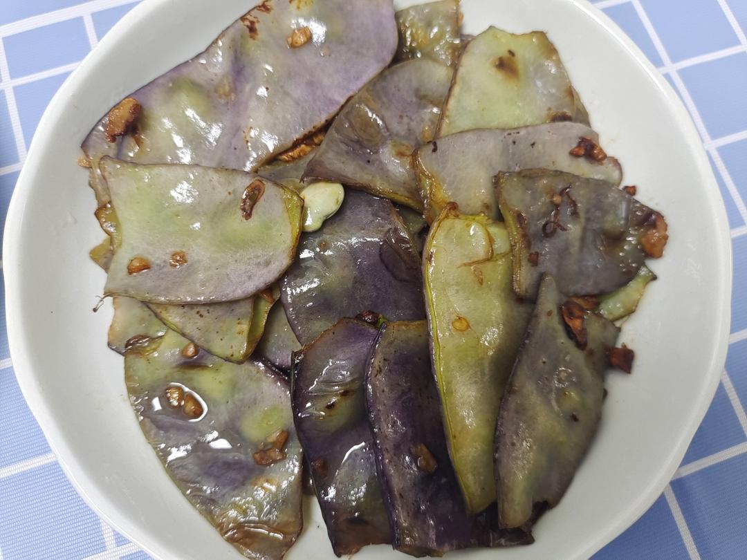 家庭厨房中正在翻炒紫扁豆的场景