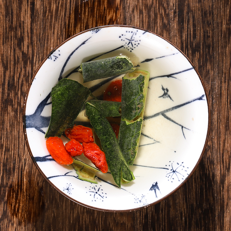 白色瓷碗中盛放的木瓜普洱茶汤,呈浅红褐色,可见细碎木瓜果肉,旁边摆放一片新鲜木瓜与一小撮普洱茶叶,整体风格清新自然,突出健康饮食主题 木瓜普洱茶成品饮品展示