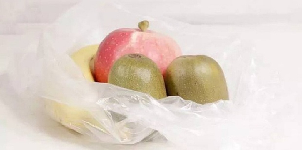 厨房场景中猕猴桃与苹果香蕉共置于透明密封袋内进行催熟