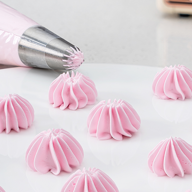 一位厨师正在用裱花袋在蛋糕表面挤出奶油玫瑰花