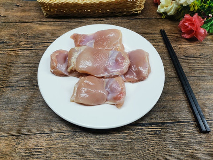 新鲜鸡腿肉被切成均匀的块状,土豆和胡萝卜分别去皮并切成大小相近的滚刀块,生姜切片,大葱切段,所有食材整齐摆放在白色瓷盘中,背景为厨房操作台 食材切配图