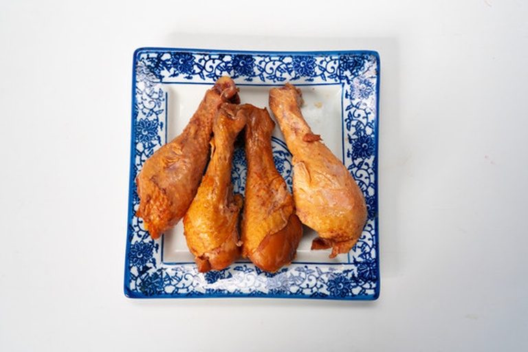 一盘红亮诱人的鸡腿整齐摆放在白色瓷盘中,表面覆盖着浓稠酱汁,点缀着翠绿葱花,旁边配有白米饭和清炒西兰花 成品懒人版鸡腿装盘效果