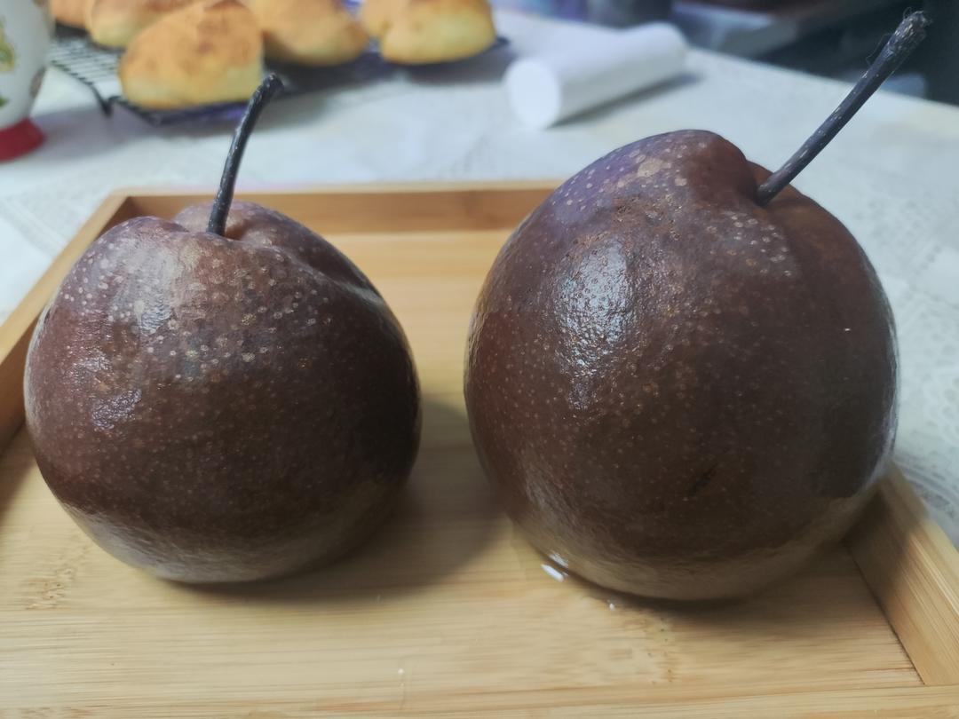 一个果盘中摆放着切片的酸梨与几颗杏仁和核桃,背景为木质餐桌,营造出自然健康的饮食氛围 酸梨与坚果搭配的健康果盘