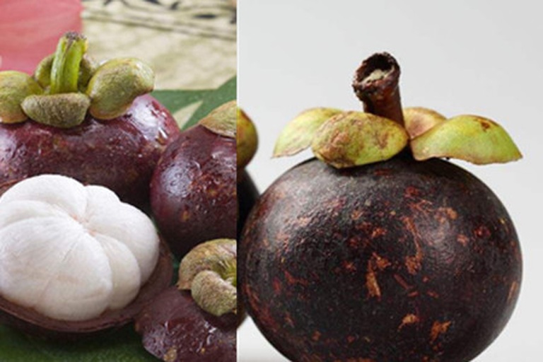 一个被横向切开的成熟山竹,露出洁白如蒜瓣的果肉,果肉饱满紧实,汁水充盈,背景为黑色衬布以突出果肉色泽,旁边有一把不锈钢小勺用于比例参照 切开的山竹果肉特写