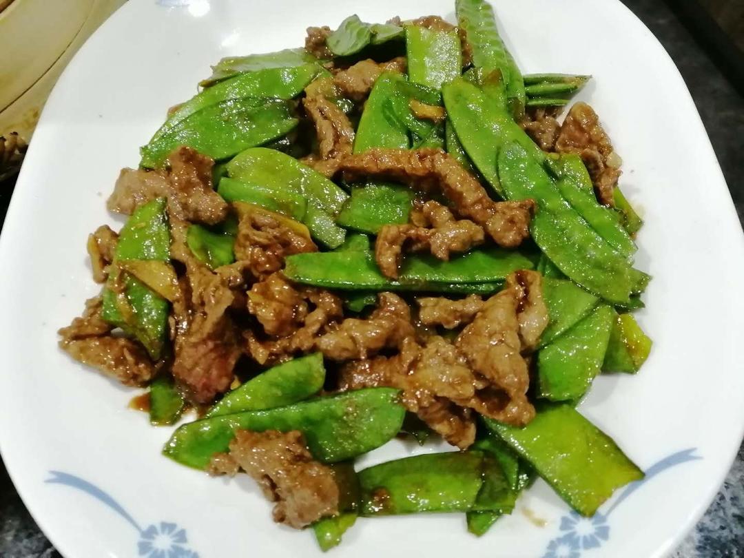牛肉荷兰豆炒制过程中,牛肉与荷兰豆翻炒均匀,锅中热气腾腾 牛肉荷兰豆炒制过程