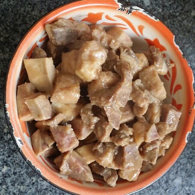 一道完成的芋头炖肉摆盘图,菜肴盛放在浅口陶瓷碗中,表面撒有少许葱花点缀,右侧配有一碗白米饭和一小碟绿色蔬菜,整体色调温暖诱人,突出家常美食氛围 成品芋头炖肉盛于白瓷碗中,肉块酥烂,芋头完整,汤汁油亮,旁边配有米饭和绿叶菜