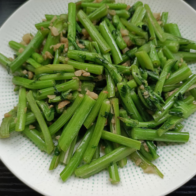 两张拼图:左侧为清炒红菜苔成品,紫红色茎条分明,配以蒜片与红椒丝点缀;右侧为白灼菜心,翠绿茎叶整齐排列,淋有浅色豉油汁,摆盘精致,体现两种蔬菜在中式家常菜中的典型呈现方式 厨房场景下的红菜苔与菜心烹饪成品图