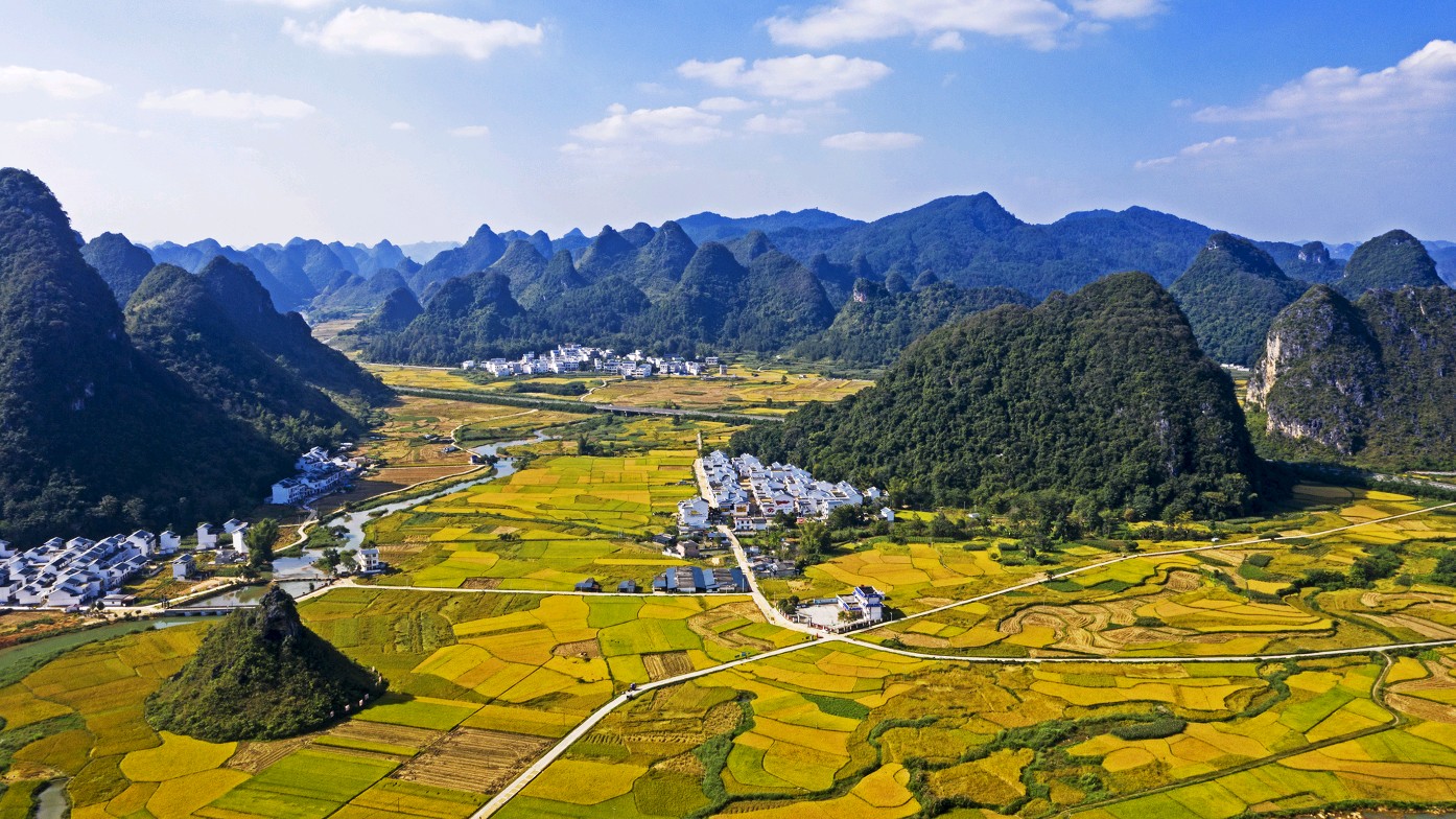 贵州省安顺市镇宁县六马镇喀斯特峰丛地貌实景航拍图:清晰呈现海拔1120–1350米的缓坡梯田式果园分布,背景可见典型锥状峰林与地下河出口,土壤呈浅褐色钙质淋溶层,标注有GPS实测坐标点(N25.85°, E105.52°) 蜂糖李原产地三维地形图