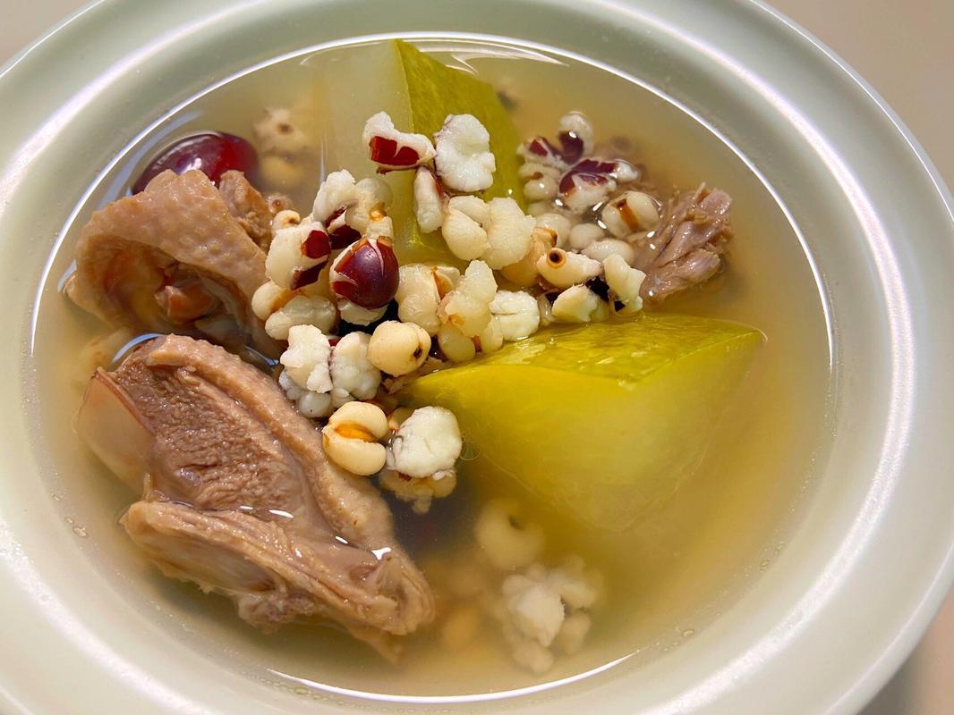 广式经典食疗方‘粉葛赤小豆薏米老鸭汤’成品图:粗陶煲盛装,汤体澄澈透亮呈淡琥珀色,表面分布细微金黄色鸭油星;粉葛块厚约1.5cm,呈半透明乳白色,边缘略软化但结构完整;赤小豆粒粒分明微绽,薏米乳白饱满,老鸭腿肉纤维清晰可见,汤面浮3颗鲜红枸杞点缀 广式粉葛赤小豆薏米老鸭汤成品特写,陶煲内汤色清亮微黄,浮有细小油星,可见粉葛块呈半透明乳白状、边缘微融,赤小豆饱满裂开,老鸭肉纤维清晰,汤面撒有少量枸杞增色