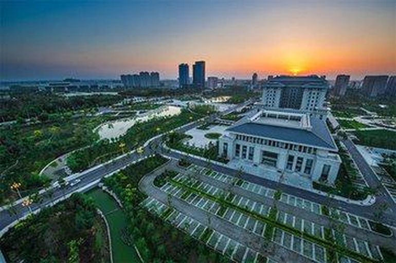 黄昏下的城市公共绿地景观,数棵高度约6-8米的阔叶树木整齐排列在步道两侧,树冠上挂满圆形果实,在夕阳照射下呈现温暖的橙黄色调,天空呈渐变粉紫色,有几位市民在小径上散步,整体氛围宁静祥和 傍晚时分的城市绿地全景图,远处高楼林立,近处是一片种植着多棵结果树木的绿化带,夕阳映照下果实泛着柔和光泽