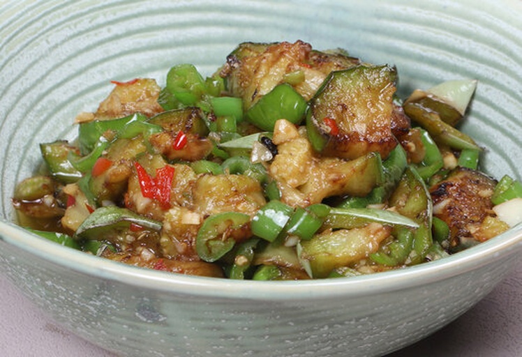 一盘刚出锅的红烧茄子,深红色酱汁包裹着切段的茄子,表面撒有绿色葱花,旁边配有白色米饭,背景为木质餐桌,光线温暖,突出菜肴的诱人质感 一盘热气腾腾的红烧茄子特写