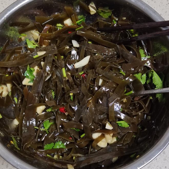 家庭级干海带科学食用示范:左侧为精确称量的3克淡干海带,中间为35℃温水浸泡20分钟后的状态,右侧为成品凉拌海带丝,色泽翠绿、口感爽脆,佐料仅含米醋、生抽、蒜末、芝麻油,无味精、无高盐 家庭厨房中干海带健康料理场景:青花瓷碗盛放凉拌海带丝(配蒜末、醋、少量芝麻油),旁边放置计量勺(显示3克干海带)和温度计(显示水温35℃)