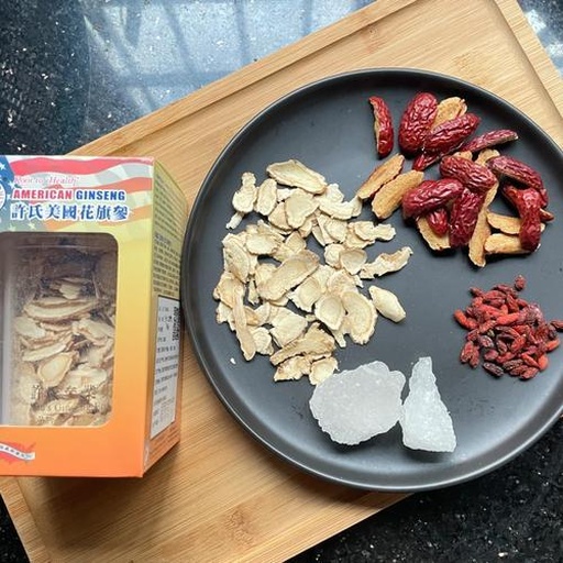 一幅生活场景图,展示三种常见花旗参食用方式:左上角玻璃杯中漂浮数片花旗参用于泡水;中部砂锅内正在炖煮花旗参鸡汤,汤色清亮;右下角小碟盛放研磨成粉的淡黄色花旗参粉,旁置小勺;背景为厨房环境,光线柔和 花旗参日常饮用方法示意图