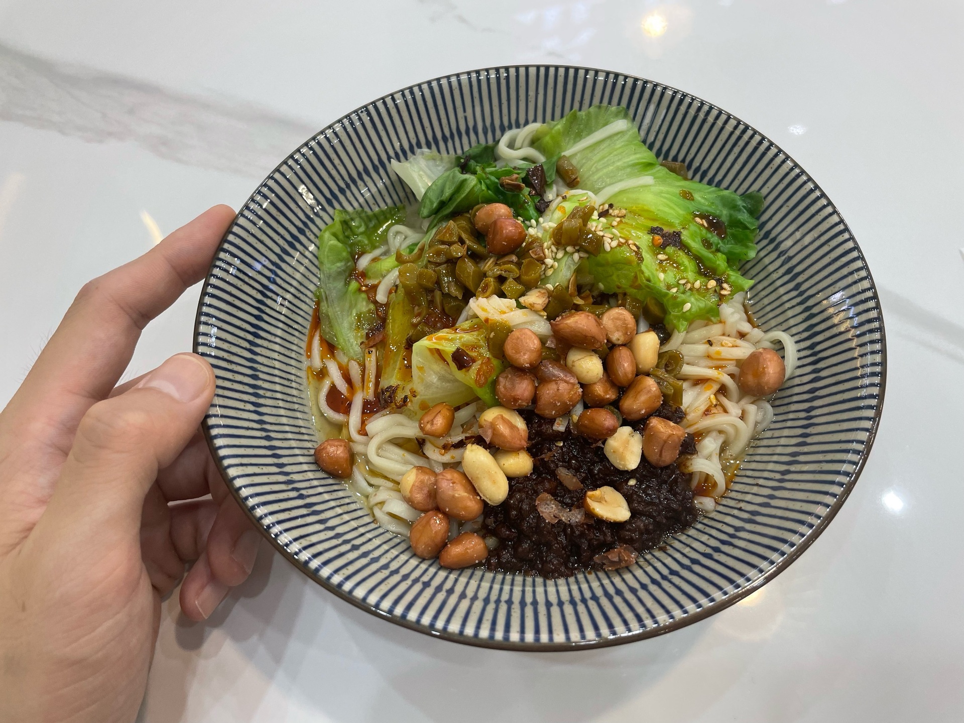 线椒拌面最终成品高清特写:强调面条油润光泽、线椒青红分明的脆嫩质感、花生颗粒饱满度及整体色彩对比度 线椒拌面成品特写:粗韧弹牙的碱水面条油亮裹汁,青红相间的线椒段清晰凸起,点缀金黄花生与翠绿葱花,碗边残留琥珀色调味汁光晕