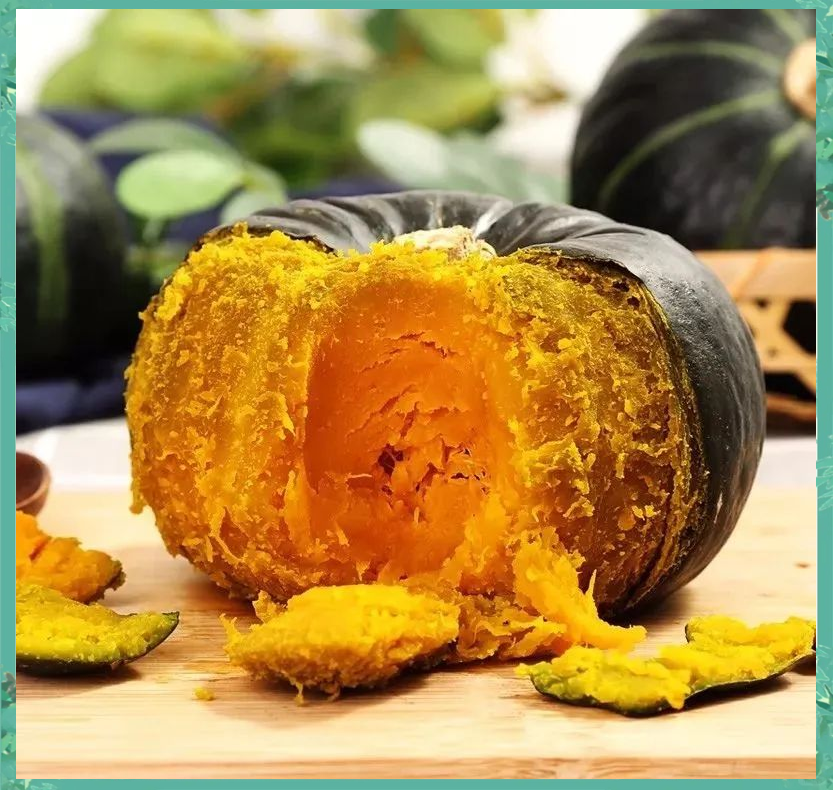 剖开的成熟老南瓜展示内部结构,果肉厚实饱满呈金黄色,种子集中在中心腔内,背景简洁干净,突出食材的新鲜与品质 切开后的老南瓜特写,露出金黄色的厚实果肉和少量籽瓤,旁边放着不锈钢勺子