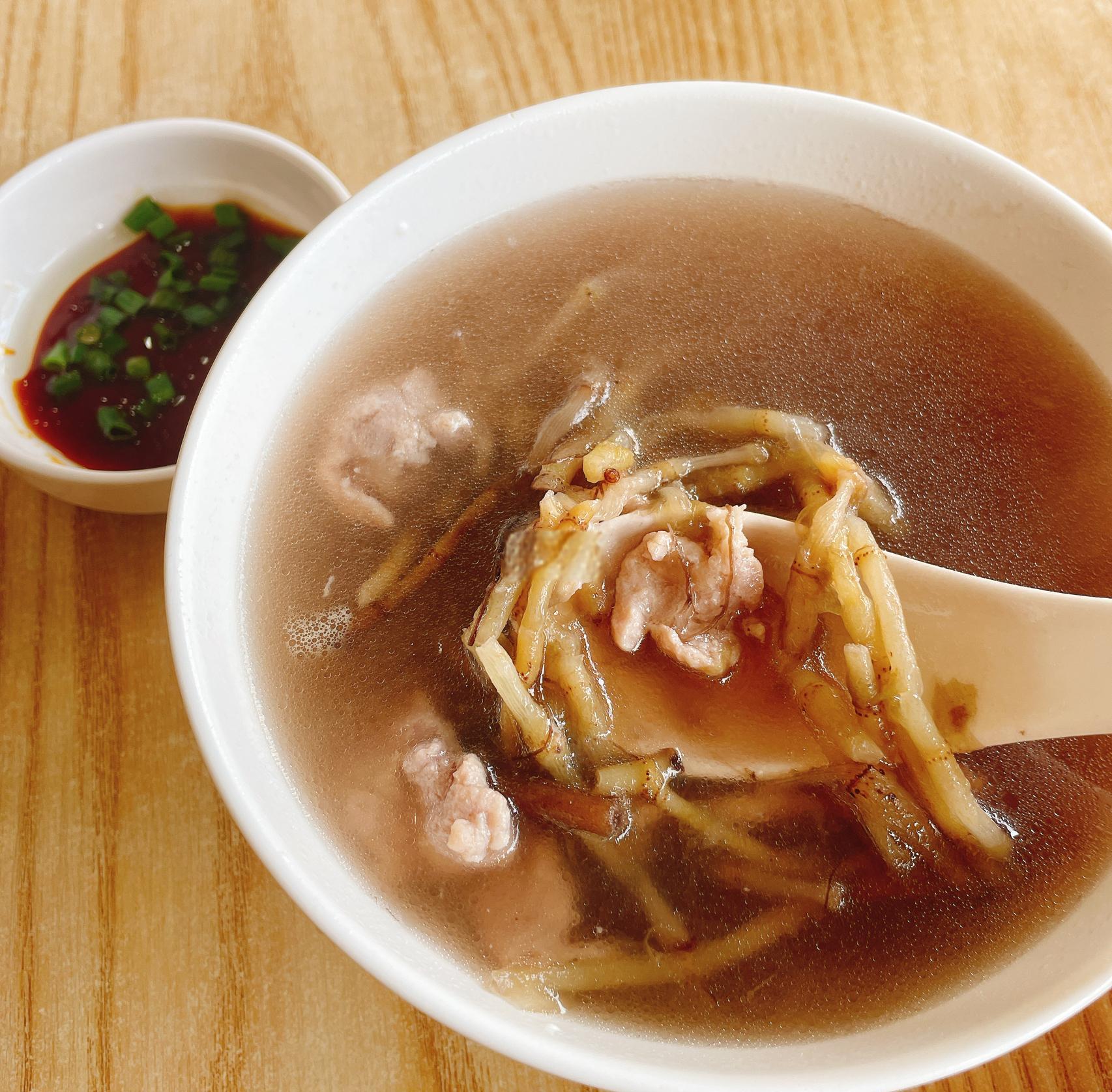 高清俯拍:深褐色浓汤中,油亮猪脚块与饱满芸豆相间,豆粒完整泛光泽,汤汁浓稠挂勺,表面浮着金黄葱花与细密油星,背景为青花瓷炖盅 芸豆炖猪脚成品特写