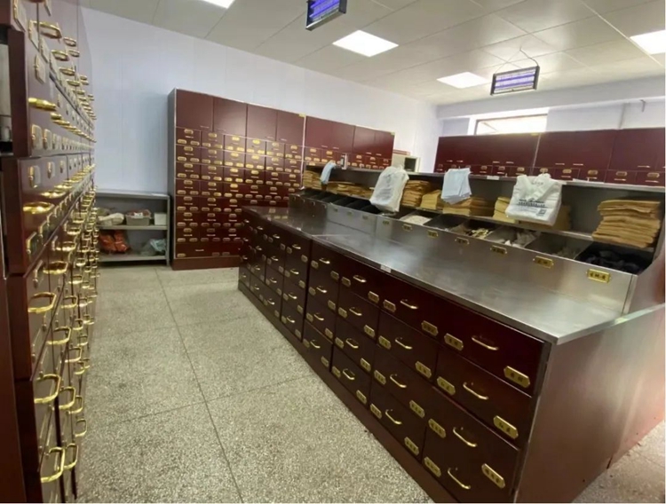 一位身穿白大褂的中医师在中药房内,手持戥秤正在称量干燥的北柴胡药材;操作台上有多个木质药斗,标签清晰标注‘北柴胡’;周围环境整洁,背景可见传统中药柜和煎药设备,体现现代中医诊疗场景 中医师正在抓取北柴胡药材