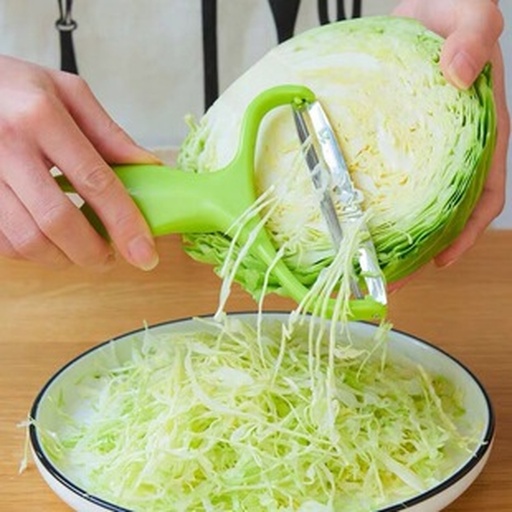 一位厨师在厨房操作台上将黄心白菜切成细丝,旁边配有 chopping board、刀具、调料瓶,锅中正炖煮着另一道白菜汤品,整体画面温馨明亮,展现家庭烹饪氛围 厨房中正在制作黄心白菜菜肴的过程图