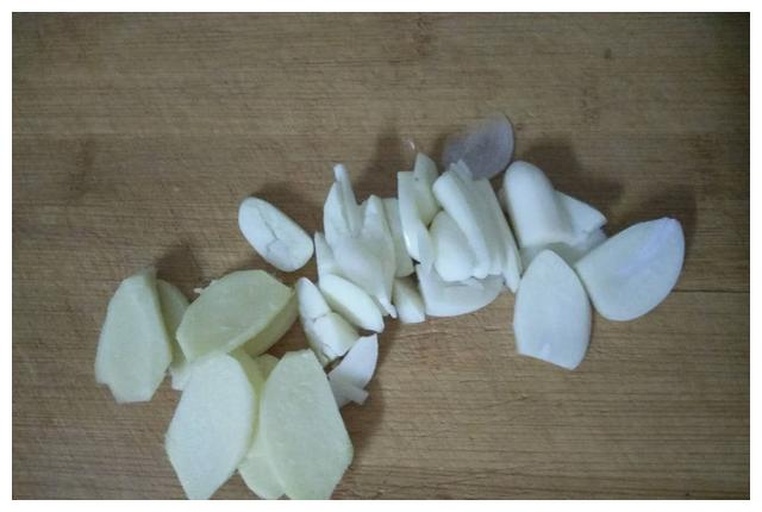 一张高清俯拍图,展示整齐摆放的新鲜莲藕切片、翠绿色的荷兰豆、泡发好的黑色木耳以及切好的蒜片和姜丝,背景为浅色木质砧板,光线柔和自然 食材摆盘图