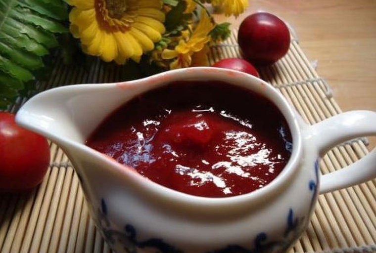 俯拍视角下,一条长条形木托盘上放置五小碟色彩各异的酱料,中间是一大盘翠绿色拍裂小黄瓜,每碟酱旁标注名称标签,如‘蒜香醋辣’‘泰式柠檬’等,整体构图整洁专业,适合美食图文内容 小黄瓜搭配不同酱料的餐桌场景